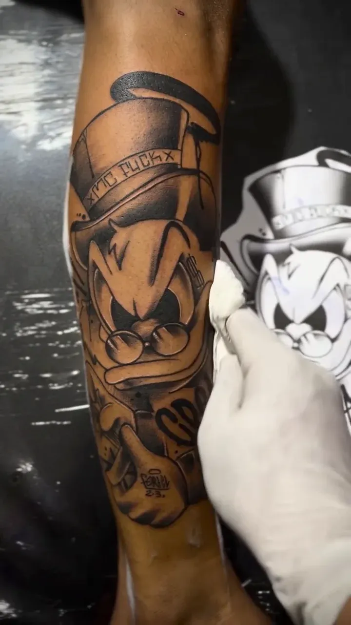 Shaded ghost tattoo with nails across its hat, finished on a forearm