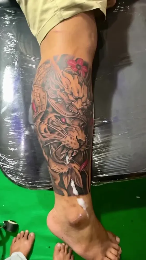 Half sleeve on a lower leg with a lynx, an oni and a compass, colour accents