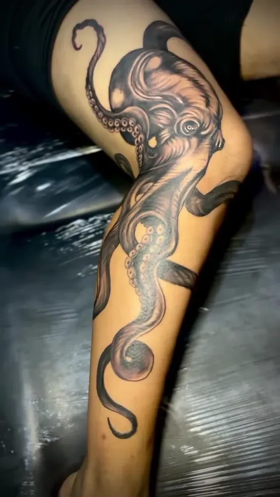 Black and grey octopus wrapping a lower leg, fine shading and texture