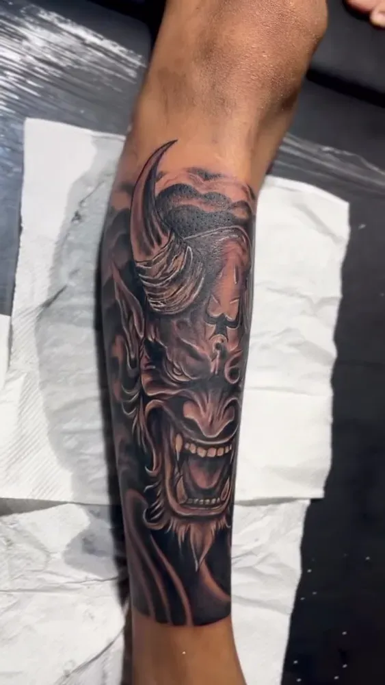 Oni mask tattoo finished on a forearm