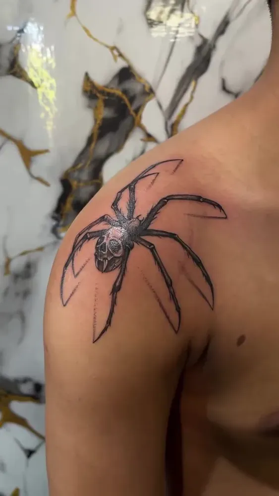 Realistic spider tattoo finished on a shoulder